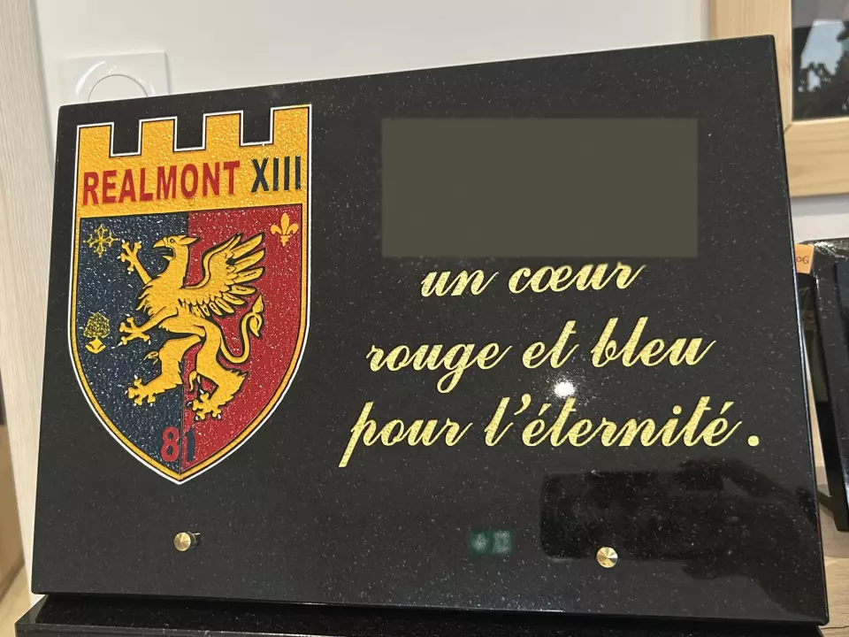 Plaque en granit noir portant le blason peint du club de rugby de Réalmont et une dédicace dorée