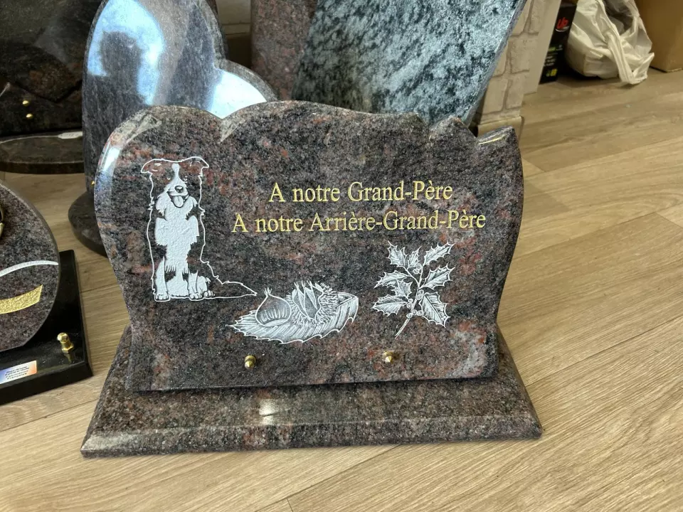 Plaque en granit gravée d'un chien et d'une branche, portant la dédicace « À notre Grand-Père »